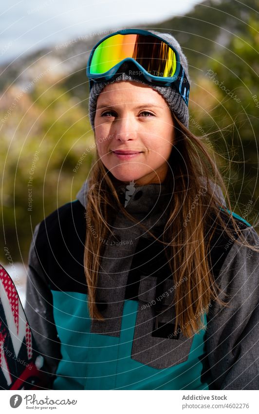 Junge Frau in warmer Sportkleidung mit Mütze und Skimaske Winter kalt positiv Mundschutz aktiv Aktivität Saison Skifahrer warme Kleidung Sportbekleidung