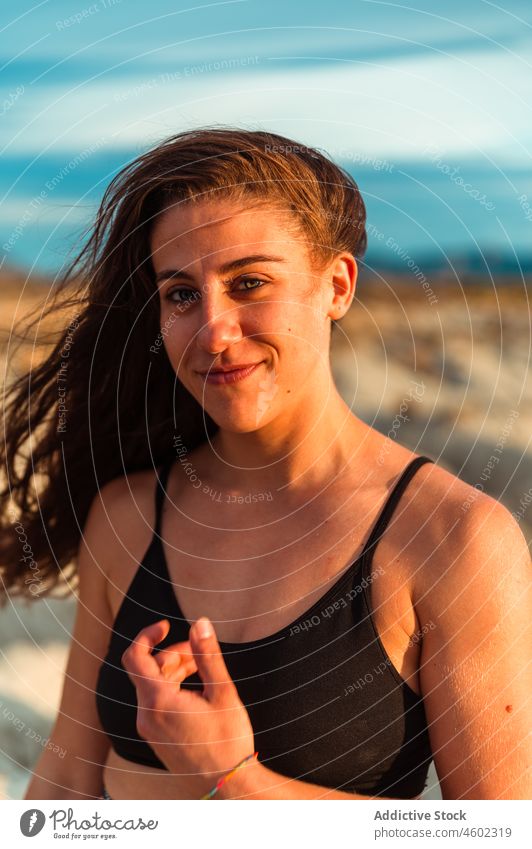 Junge positive Frau mit nassen Haaren am Meeresstrand heiter nasses Haar Natur Meeresufer Küstenlinie Menschliches Gesicht Sommer Porträt Lächeln Model