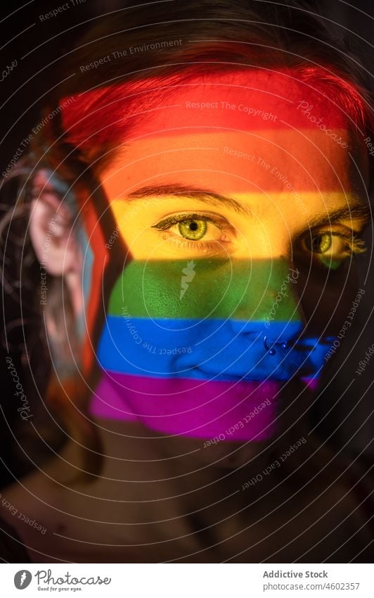Junge lesbische Frau unter LGBT-Flagge lgbt lgbtq Fahne Regenbogen Stolz Konzept Liebe Projektor hell farbenfroh leuchten rechts lebhaft Homosexualität Toleranz