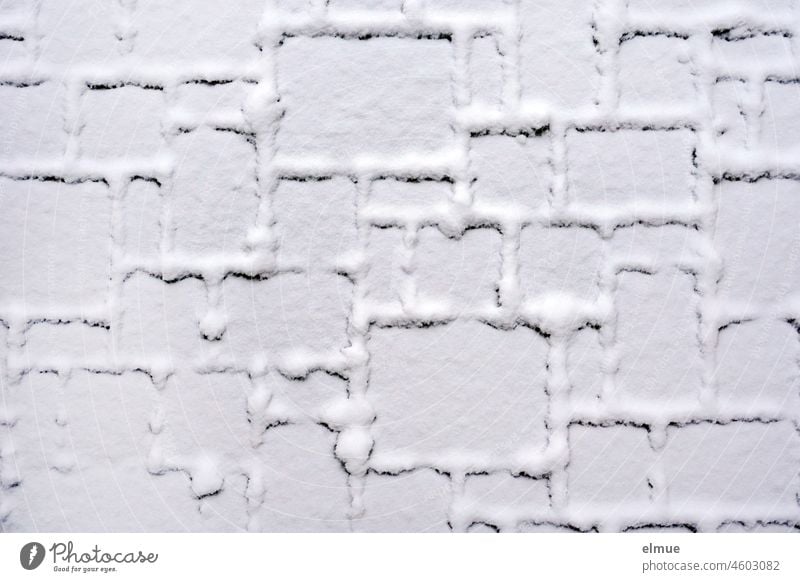 mit Schnee bedeckte Fläche aus Pflastersteinen unterschiedlicher Größe / Winter / Muster schneebedeckt Rechteck Geometrie Naturstein Altstadtpflaster