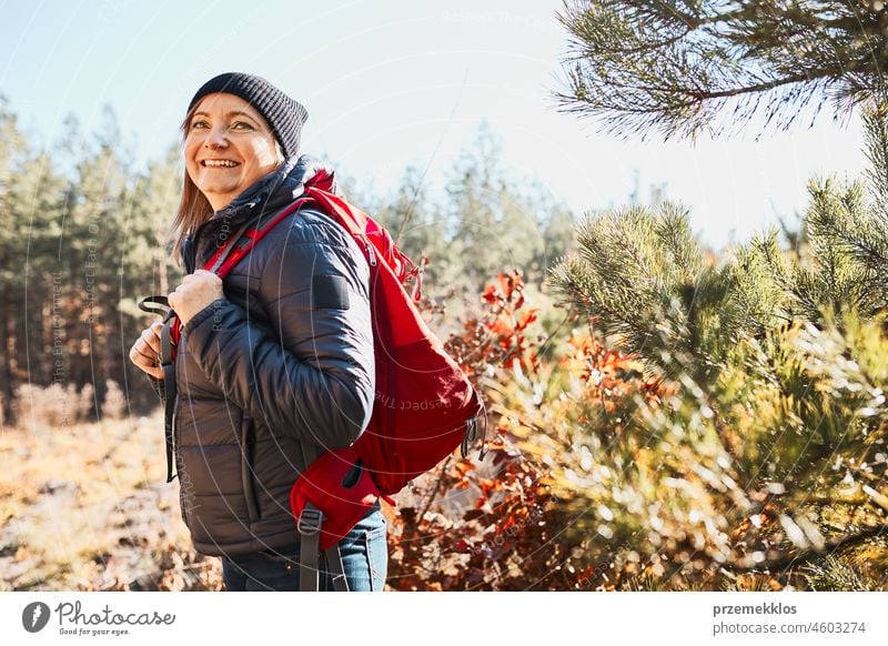 Lächelnde Frau, die eine Wanderung an einem sonnigen Urlaubstag genießt. Frau mit Rucksack zu Fuß durch den Wald Ausflug wandern Abenteuer reisen Sommer Reise