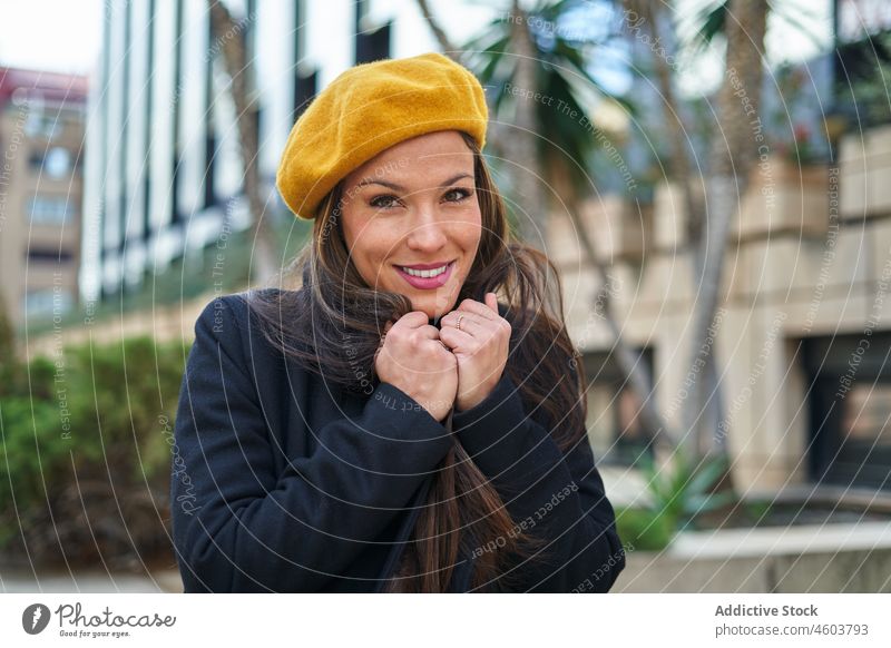 Zufriedene Frau im Mantel, die auf der Straße friert Unternehmer Großstadt Stil Porträt feminin Mode urban kalt Einfrieren respektabel elegant positiv Lächeln