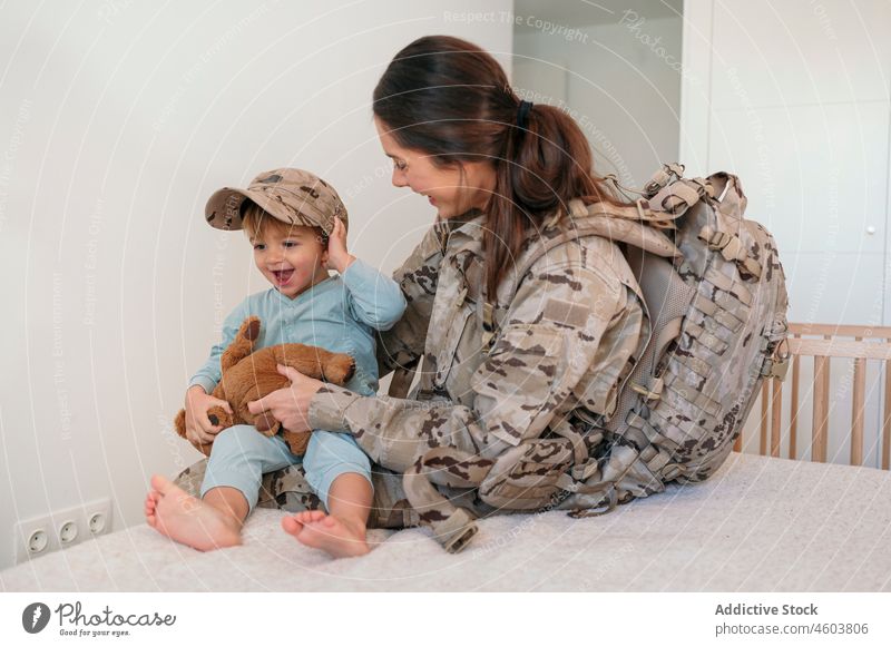 Militärfrau setzt ihrem Sohn eine Mütze auf Mutter Glück Soldat Armee Pflicht Junge Lächeln Mutterschaft Verschlussdeckel spielen Spielzeug Patriotin Kind