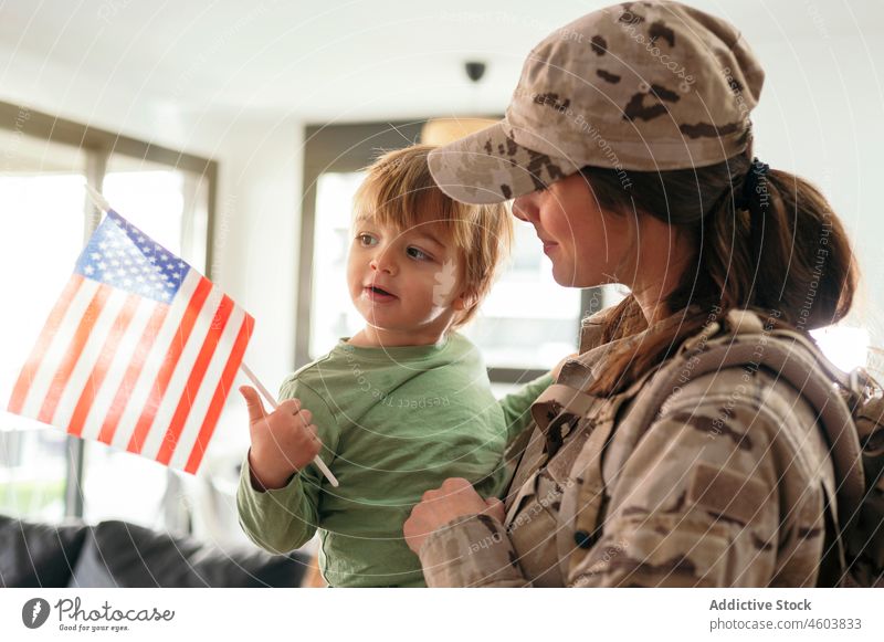 Gesichtslose Militärfrau mit Sohn im Arm Mutter Soldat Pflicht Junge Gruß Dienst ankommen Fahne Amerikaner Patriotin Kind niedlich Liebe Zusammensein