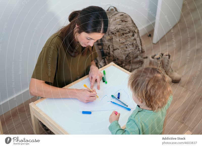 Militärische Mutter und Sohn zeichnen im Spielzimmer Hobby Soldat Junge Mutterschaft Freizeit Kindheit Pflege Patriotin niedlich Liebe Dienst Filzstift