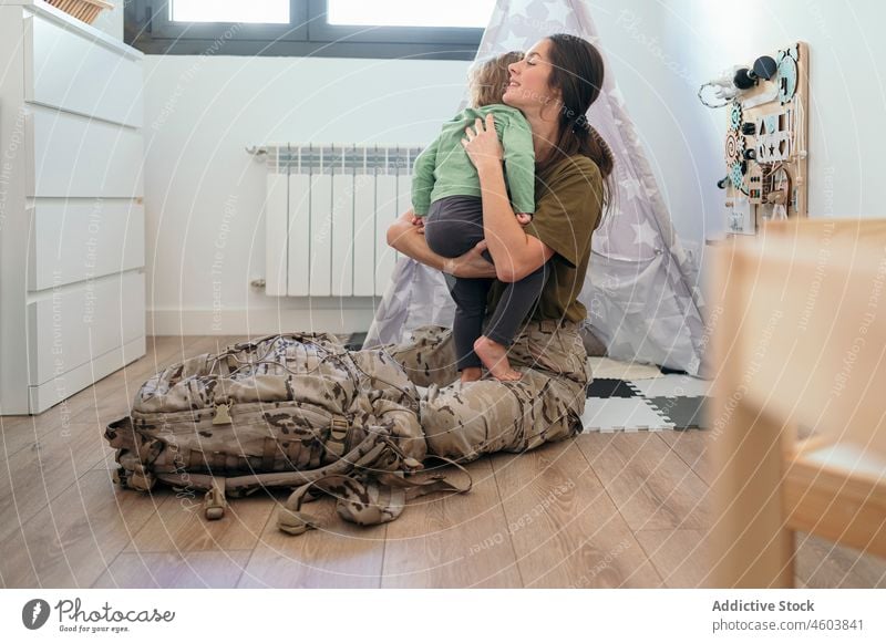 Militärfrau umarmt gesichtslosen Sohn Mutter Soldat Pflicht Junge ankommen Umarmung Streicheln Mutterschaft Spielzimmer Pflege Patriotin Kind niedlich Liebe