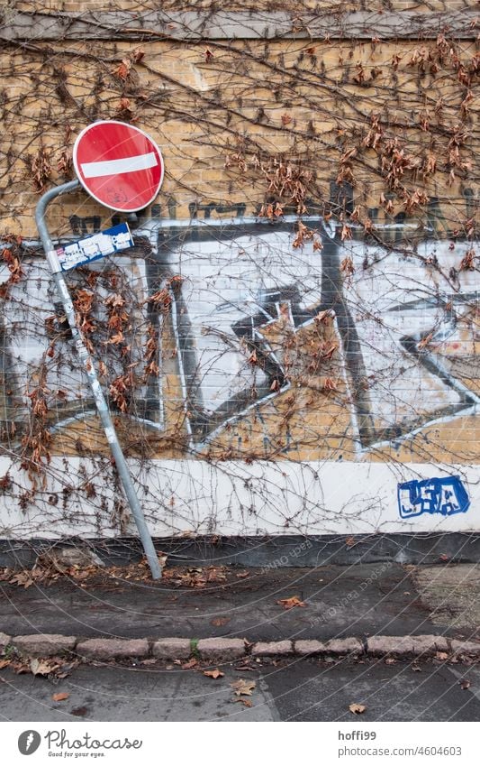 Plattgefahrenes Einbahnstrassen Schild vor einer Hauswand plattgefahren Einbahnstraßenschild Durchfahrtsverbot Deformation zerbeult Schrott kaputt Zerstörung