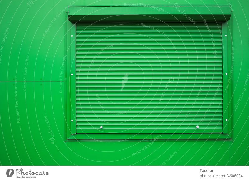 Grüner Fensterladen auf grüner Wand . Sicherheit zugeklappt Außenseite Licht modern Rolle Detailaufnahme Gebäude Appartement blind wirtschaftlich