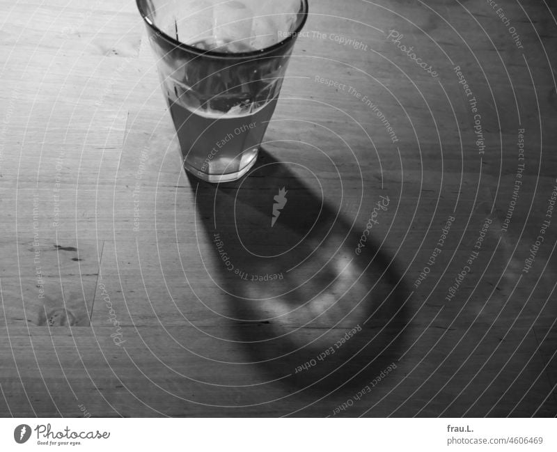 Bierglas mit oder im Schatten Wasserglas Getränk Alkohol Abend Reflektion Holztisch abgestanden schal