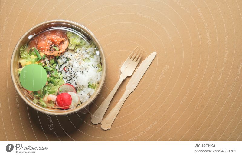 Gesundes Salat-Mittagessen mit Lachs in Schalen aus recyceltem Bastelpapier mit Holzbesteck. Ansicht von oben. Nachhaltige Lebensmittellieferung. Reduzieren Sie Plastik. Umwelt und umweltfreundlicher Lebensstil