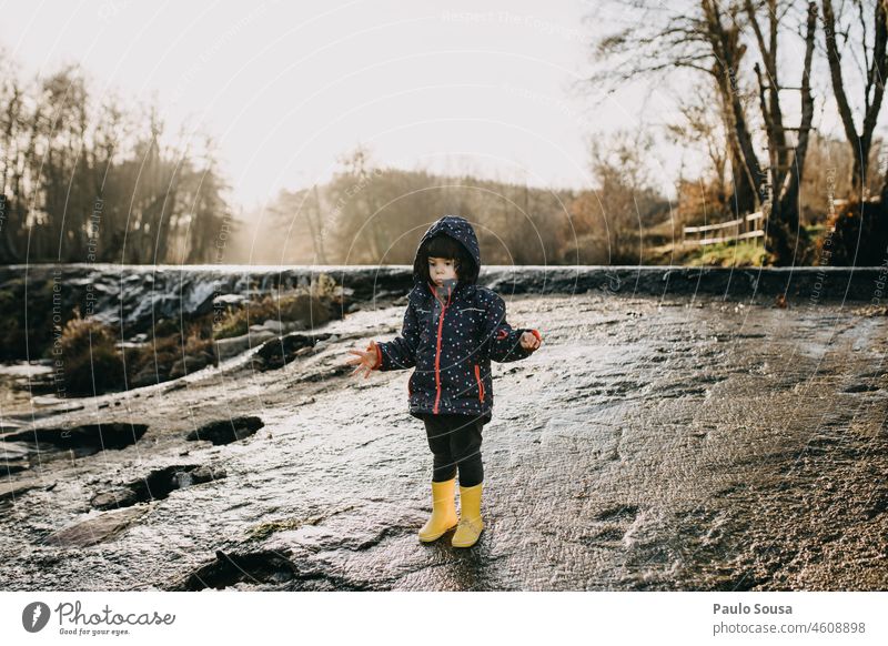 Niedliches Mädchen mit gelben Gummistiefeln Kind Kindheit 3-8 Jahre Kaukasier eine Person authentisch Winter Fluss Freizeit & Hobby Fröhlichkeit Tag Spielen