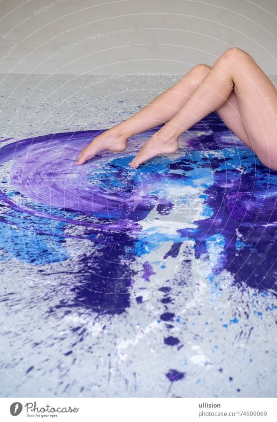 schöne Beine und Füße einer sexy jungen Frau Ballerina auf dem künstlerisch abstrakten lila, blau und weiß bemalten Atelierboden, Kopierraum. purpur magenta