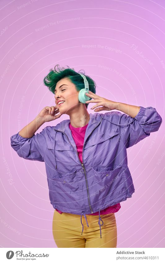 Frau in Retrokleidung hört Musik Kopfhörer meloman Stil tausendjährig 80s Mode Design retro Gesang zuhören Audio Atelier grünes Haar Model Kurze Haare Vorschein