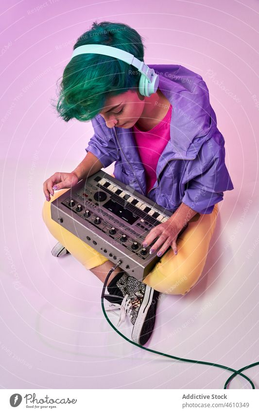Von oben Inhalt Millennial-Frau mit Kopfhörern spielt auf Keyboard-Controller spielen Regler komponieren tausendjährig 80s Musik Musiker Stil Mode Design retro