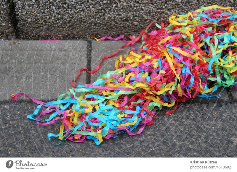 papierstreifen aus einem luftschlangenwerfer liegen im rinnstein boden straße gehweg bürgersteig party feier fest karneval fasching silvester neujahr