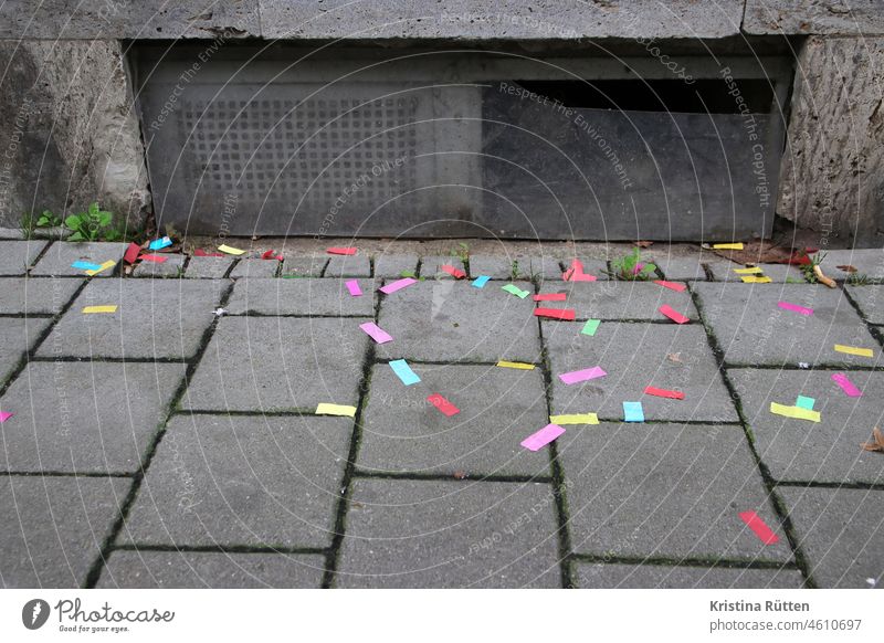 bunte konfetti schnipsel liegen vor einem kellerfenster auf dem bürgersteig papier papierschnipsel papierfetzen farbig karneval fasching silvester neujahr