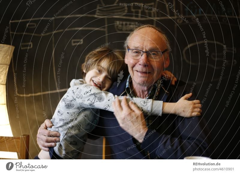 Enkel umarmt seinen Opa Großvater Männlicher Senior Mann Kind Junge 2 60 und älter Freude Glück Zufriedenheit Kindheit Farbfoto Erwachsene Fröhlichkeit