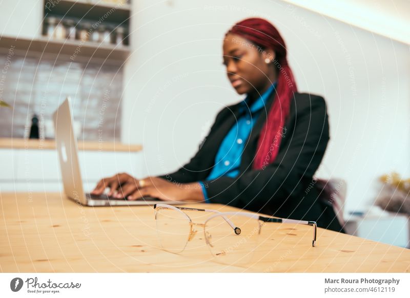 Frau mit roten Zöpfen arbeitet an einem Laptop Büro Brille Homeoffice