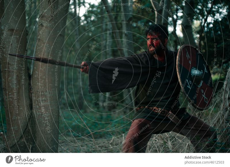 Aggressiver Krieger, der mit Speer und Schild kämpft Mann Wikinger Schutzschild kämpfen mittelalterlich wütend Blut Waffe Wiederaufbau männlich Nachstellung