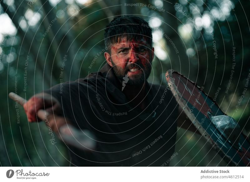 Aggressiver Krieger, der mit Speer und Schild kämpft Mann Wikinger Schutzschild kämpfen mittelalterlich wütend Blut Waffe Wiederaufbau männlich Nachstellung