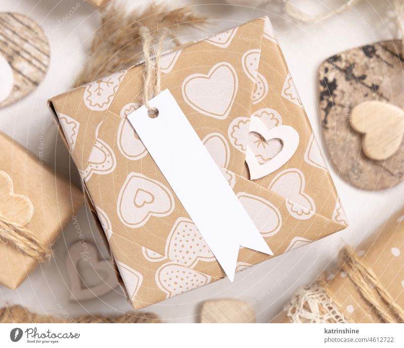 Valentines Geschenk mit leeren Geschenkanhänger und Herzen schließen, Rustic Label Mockup Valentinsgruß Attrappe präsentieren eingewickelt beige Boho rustikal