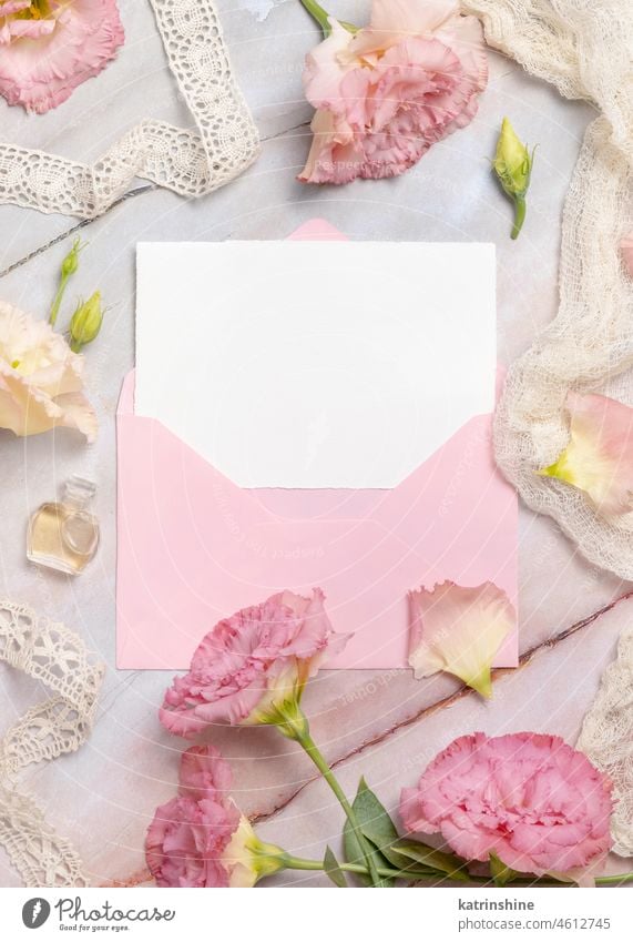 Rosa Blumen und eine leere Karte mit Umschlag liegen auf einem Marmortisch Attrappe Postkarte Gruß blanko Geburtstag Hochzeit Kuvert Murmel Tisch Rosen