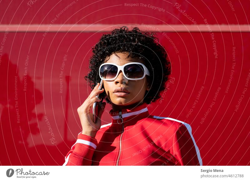Afroamerikanische Frau mit kurzen Haaren und Sonnenbrille führt ein Telefongespräch Afroamerikaner Afro-Look Kurze Haare jung Junge Frau Erwachsener