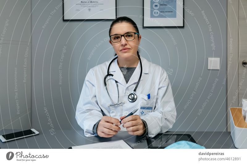 Ärztin schaut in die Kamera in ihrem Büro Arzt Frau Porträt schauende Kamera professionell Arztpraxis freundlich medizinisch Krankenhaus Mann Gesundheitswesen