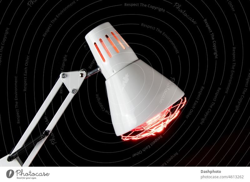 Beleuchtete Infrarot-Gesundheitslampe Nahaufnahme auf einem schwarzen Hintergrund Infrarotlampe Strahlung Lampe weiß elektrisch glühen glühend Ausstrahlung