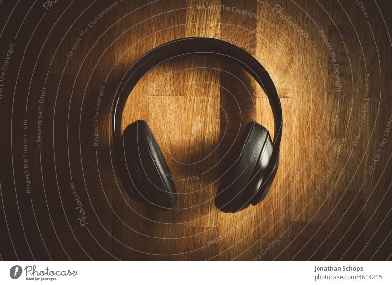 Kopfhörer Flatlay auf Holztextur Bass Draufsicht Headphones Holztisch Lautstärke Licht Minimalismus Musik Musikstreaming On Ear Podcast Reduzierung Spot