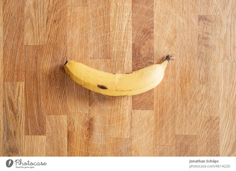 Banane Flatlay auf Holztextur Draufsicht Fasten Fastenzeit Holztisch Minimalismus Obst Reduzierung Stillleben Südfrucht gelb süß vegan Ernährung