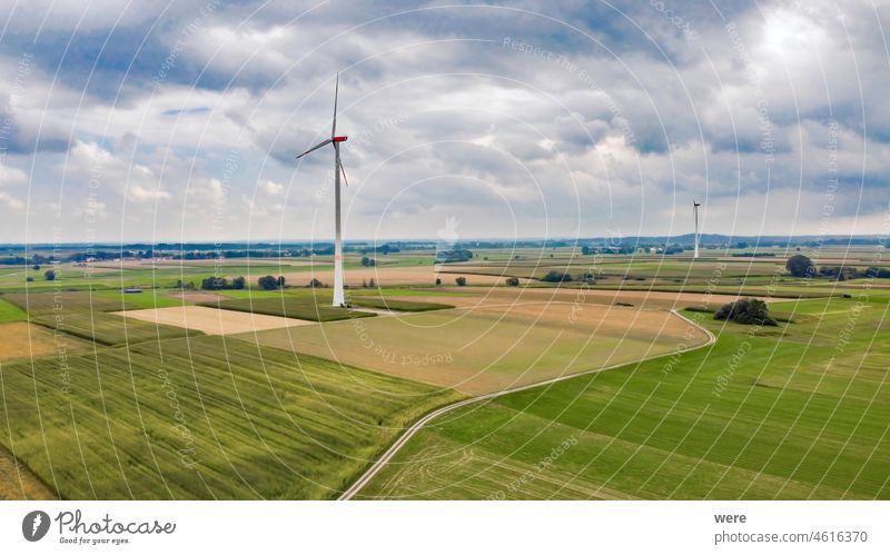 Windkraftanlagen in stürmischem, bewölktem Himmel in landwirtschaftlicher Landschaft Alternative Energie Bereich Flug Ansicht Windturbinen Luftaufnahme
