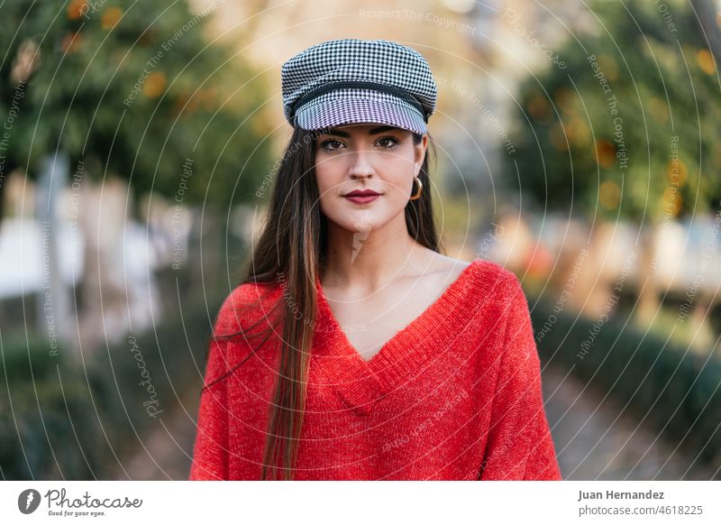 Frontalporträt einer schönen Frau in rotem Pullover und schwarz-weiß karierter Mütze frontal Porträt Nizza Plaid Verschlussdeckel Model Dame horizontal