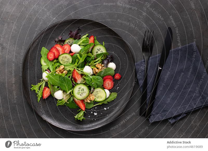Tisch mit einem Erdbeersalat neben einem Besteck appetitlich mischen Draufsicht Mozzarella Nut Gesundheit dunkel Top Gemüse Speise farbenfroh flache Verlegung