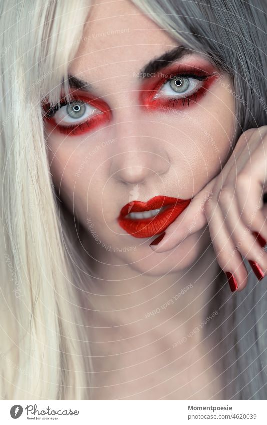 rot geschminktes Frauengesicht umrandet von weiß-grauen Haaren Beautyfotografie schön Augen Mund Lippen sexy rote Lippen schauen weißhaarig Platinblond