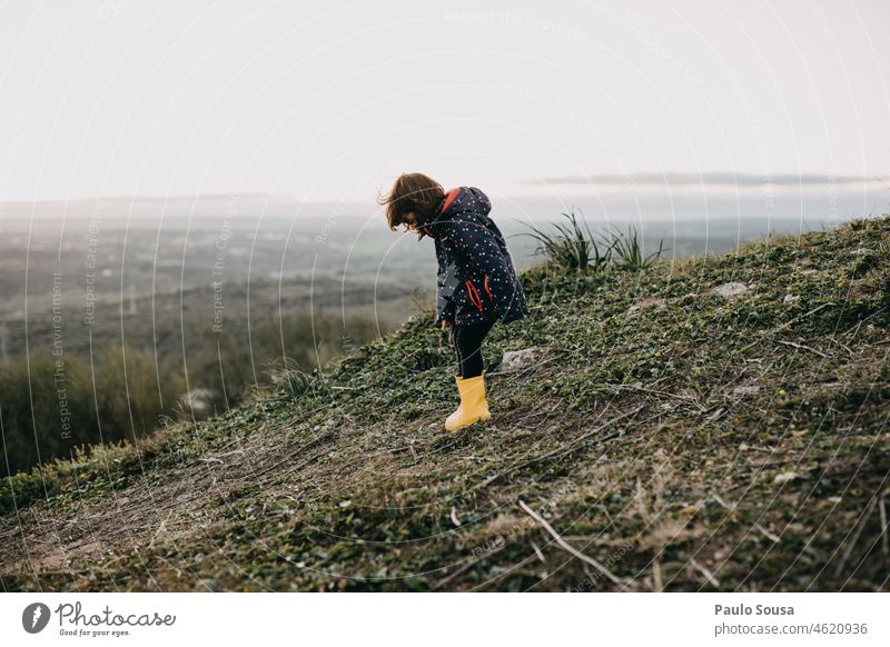 Seitenansicht eines Mädchens mit gelben Gummistiefeln 3-8 Jahre Kaukasier Winter Herbst Mensch authentisch Freizeit & Hobby Tag Freude Spielen Außenaufnahme