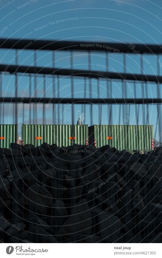 Trashige Ansicht durch Baugitter auf den Hamburger Michel, der hinter ein paar Containern hervorschaut Baustelle Struktur Gitter Wand blauer Himmel