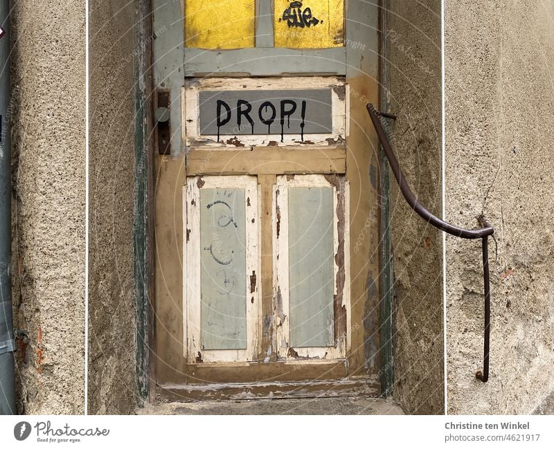 DROP! steht an der abgeblätterten Eingangstür des alten verwahrlosten Hauses Drop Wort Buchstaben schreiben Schrift Aussage Text Verständigung Kommunizieren
