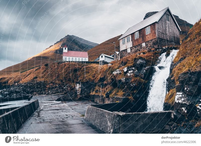 Färöer Inseln: Blick auf die Kirche Kunoyar von Miniwasserfall Saison ländlich Landschaft Färöer-Inseln malerisch Hochland kalt Berge u. Gebirge Sonnenlicht