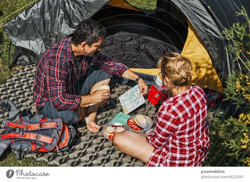 Ein Paar frühstückt und plant seinen Tag im Zelt auf dem Campingplatz. Menschen aktiv verbringen Sommerferien in der Nähe der Natur im Freien Urlaub Ausflug
