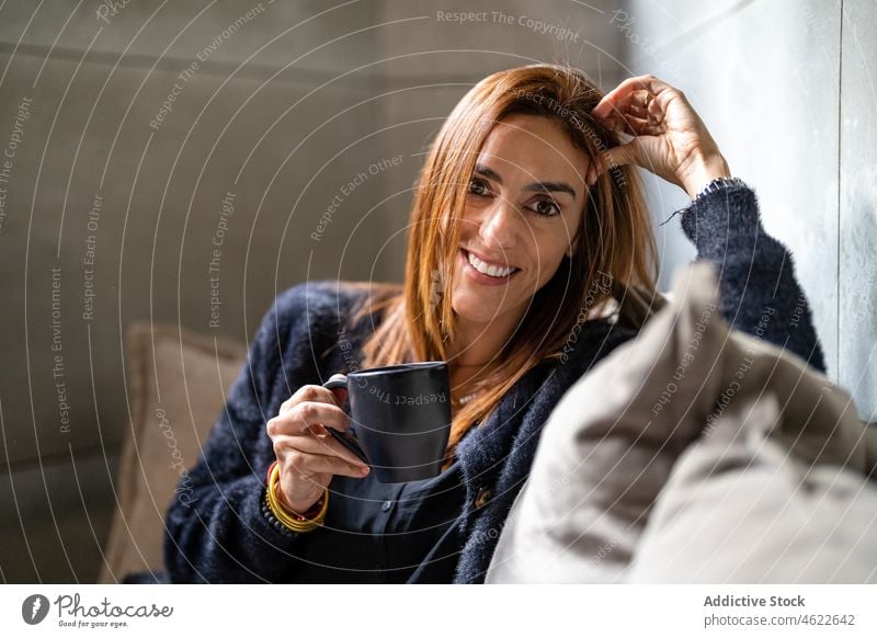 Glückliche Frau mit Kaffee im Büro sitzend Heißgetränk Pause Liege Porträt Arbeitsplatz Arbeiter Unternehmer Stil modern positiv Dame professionell