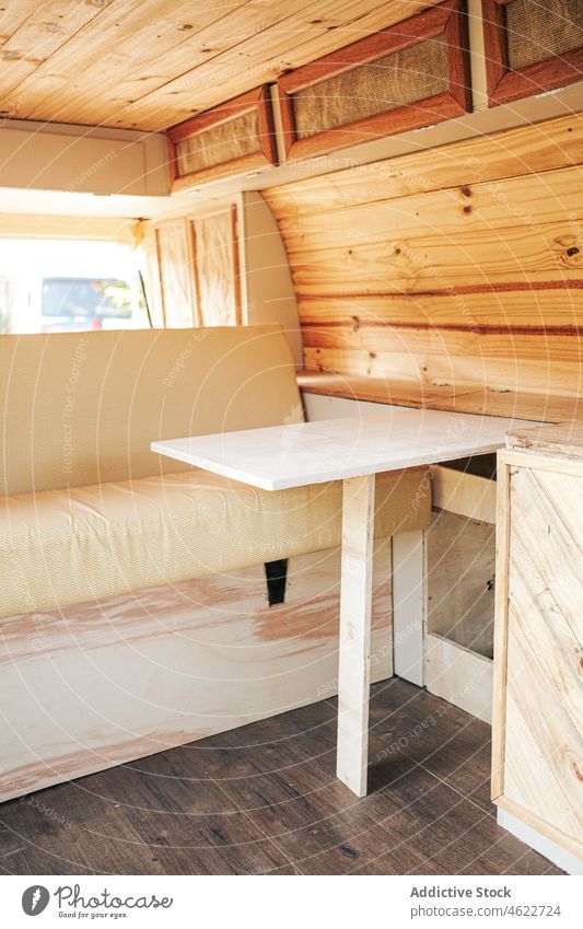 Innenraum eines Wohnmobils mit Sofa und Tisch Camping Kleintransporter Anhänger Bett Innenbereich Autoreise Kabinett Ausflug Wohnwagen Unterkunft lebend hölzern