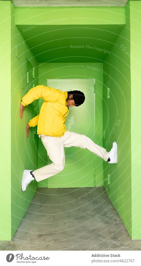 Mann springt in grüne Ecke springen Gebäude Durchgang Energie Aktivität Haus Stil aktiv männlich Straße wohnbedingt urban Bewegung Aktion hell farbenfroh