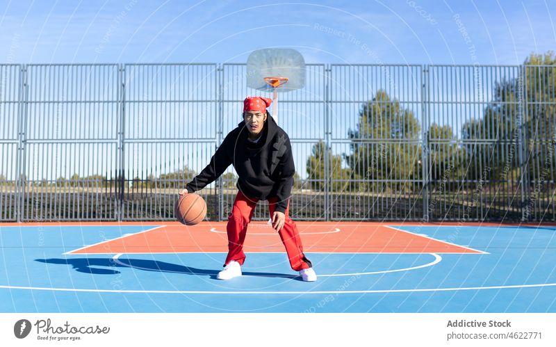Asiatischer Mann dribbelt Basketball auf dem Spielplatz Trick Fähigkeit Ball Porträt Sportpark dribbeln Hobby Training asiatisch Zaun männlich Aktivität Spieler