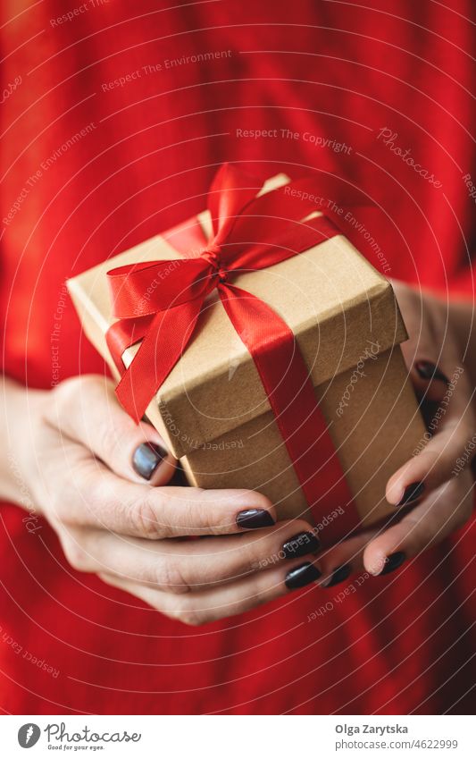 Weibliche Hände halten ein Geschenk. Kasten rot Valentinsgruß Weihnachten präsentieren Tag Beteiligung Geben Feiertag Nahaufnahme Textfreiraum Geschenkbox