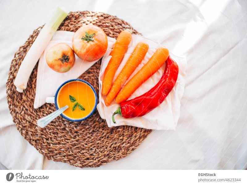 Vegane Kürbiscreme in einem emaillierten Becher mit Gemüse, Paprika, Lauch und Tomaten von oben Suppe Lebensmittel Schalen & Schüsseln Mahlzeit Herbst Sahne