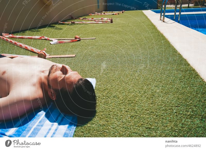 Junger Mann in einem Pool mit Einschränkungen der sozialen Distanz COVID Pandemie covid-19 männlich Feiertage Sommer Sommerzeit Schwimmbad ansteckend Risiko