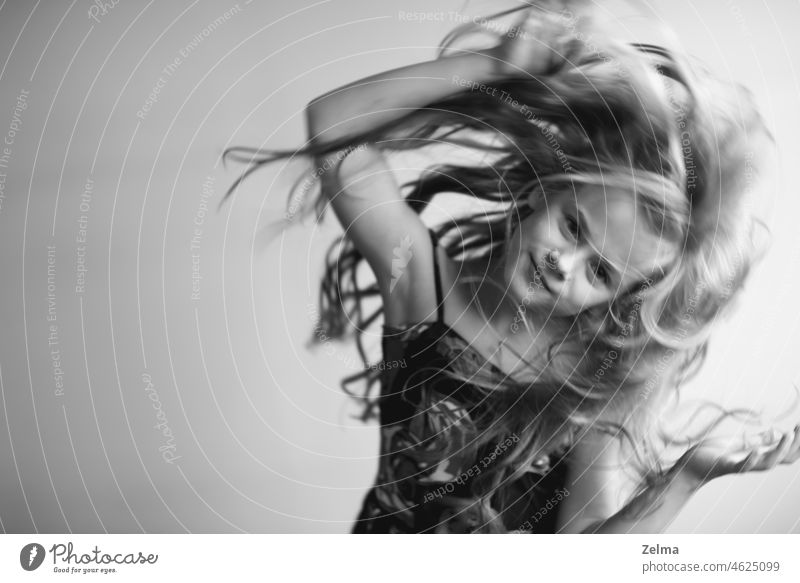 Porträt eines kleinen Mädchens mit langen gesunden Haaren in Bewegung Kind schwarz weiß Schwarzweißfoto Bewegungsunschärfe Tanzen Studioaufnahme wenig