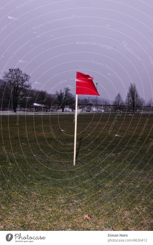 Rote Fahne, Wind und Schneeflocken rot Markierung Orientierung Eckpunkte Richtung Wegweiser Gefahr Hinweis Achtung stürmisch Navigation hinweisen grauer Himmel