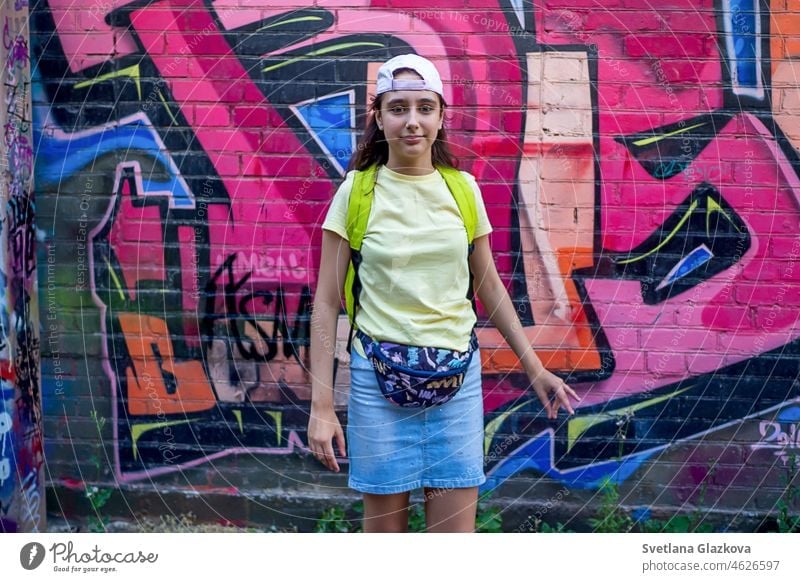 Teenager Mädchen Porträt auf der Straße vor dem Hintergrund der Wand mit Graffiti Straßenkunst Straßenfotografie Spaß haben gen z Generation z Großstadt Mode
